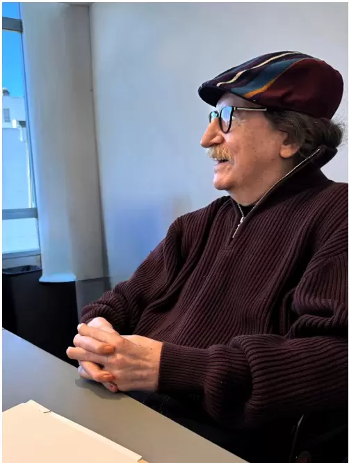 Charly posando sonriente en las oficinas del sello discográfico luego de la firma, luciendo la boina que le regaló un fan.